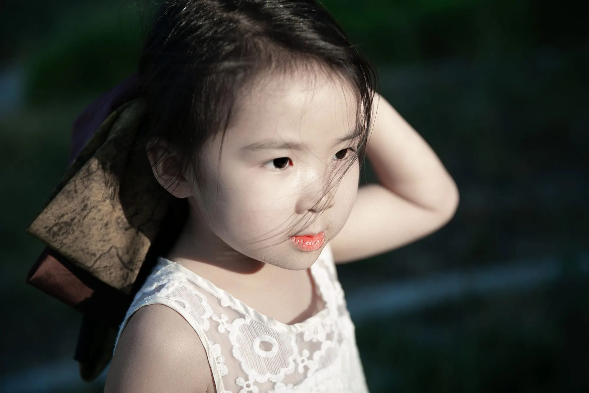 Little girl holding a pink blossom at golden hour, frame 4 of 10
