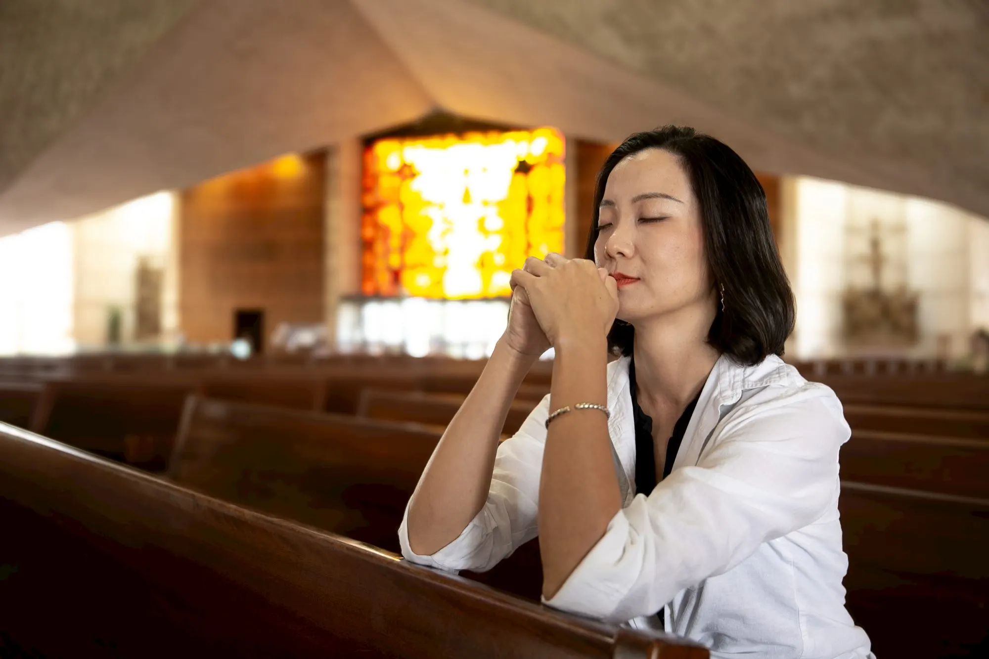 Portrait in a church pew under stained glass, frame 13 of 18