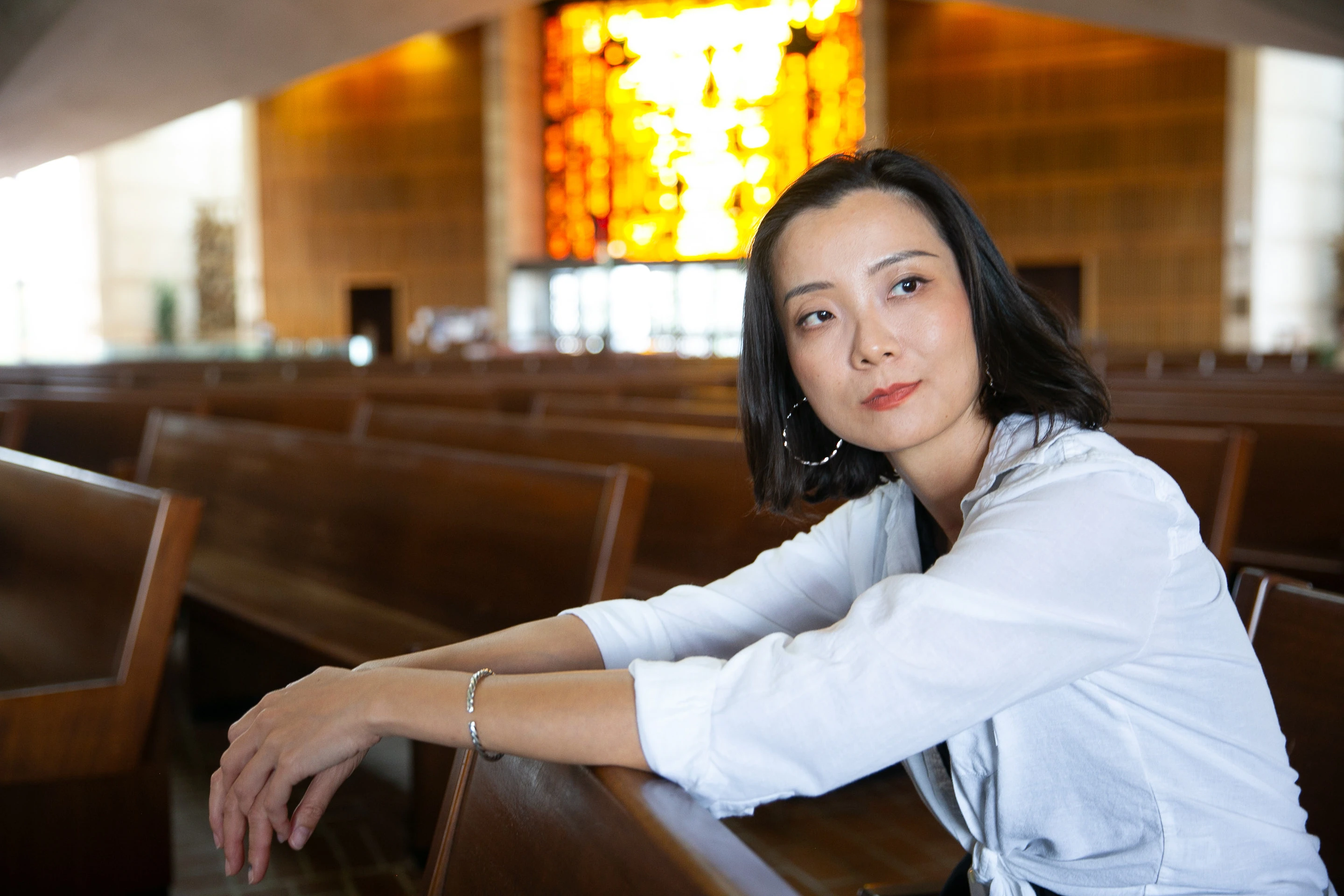 Portrait in a church pew under stained glass