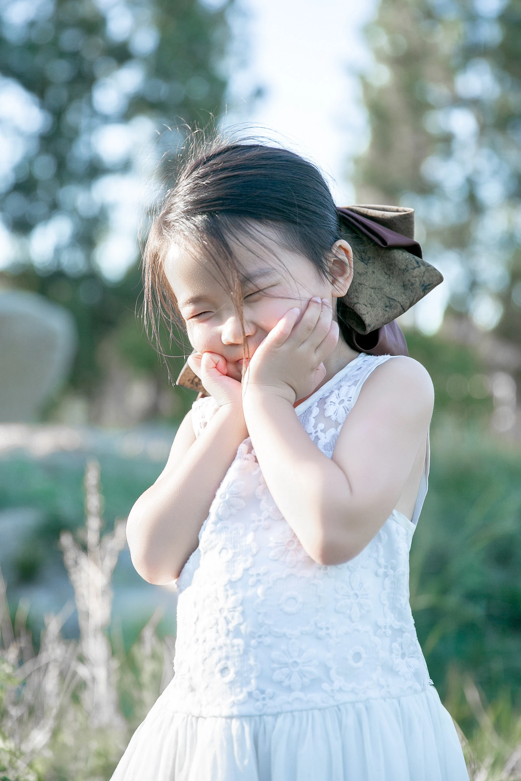 Little girl holding a pink blossom at golden hour