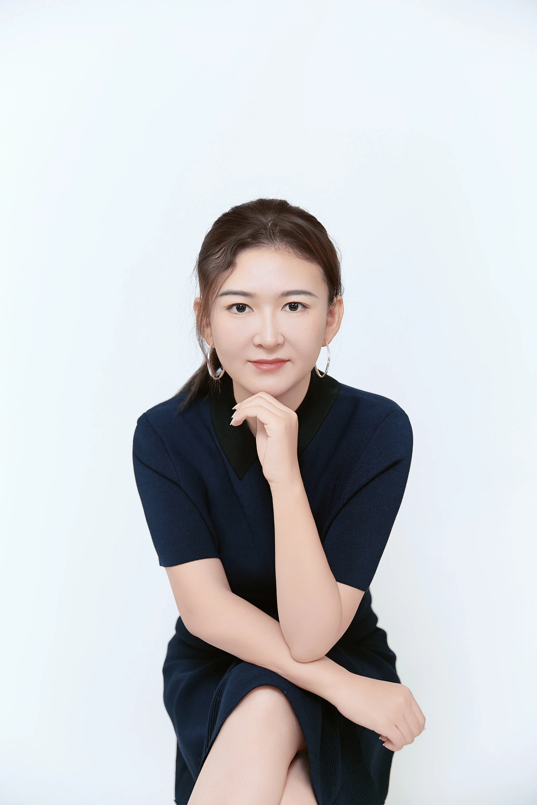 Studio headshot in a navy dress