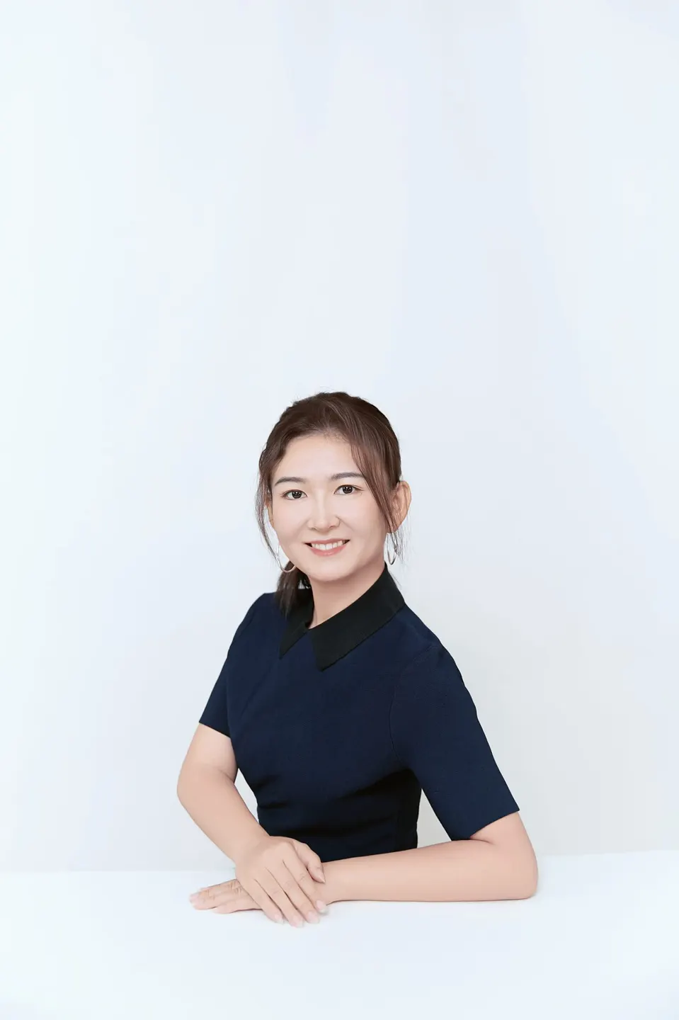 Studio headshot in a navy dress, frame 3 of 9