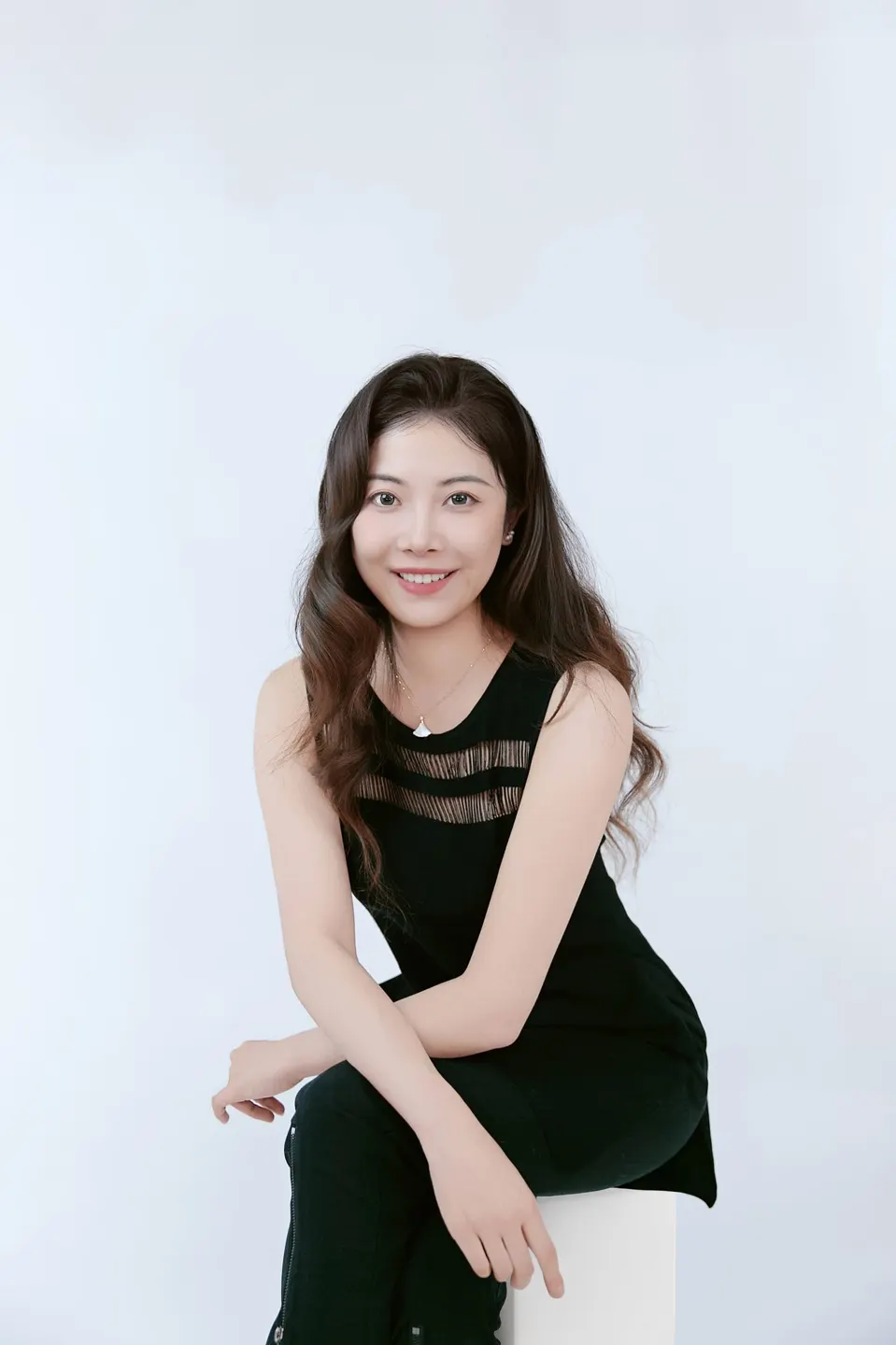 Studio headshot in a navy dress, frame 7 of 9