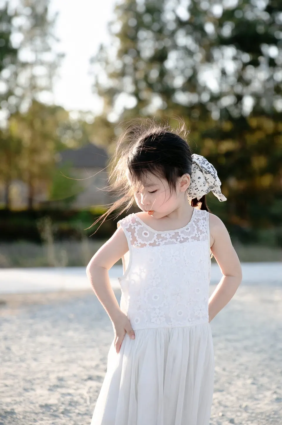 Little girl holding a pink blossom at golden hour, frame 8 of 10